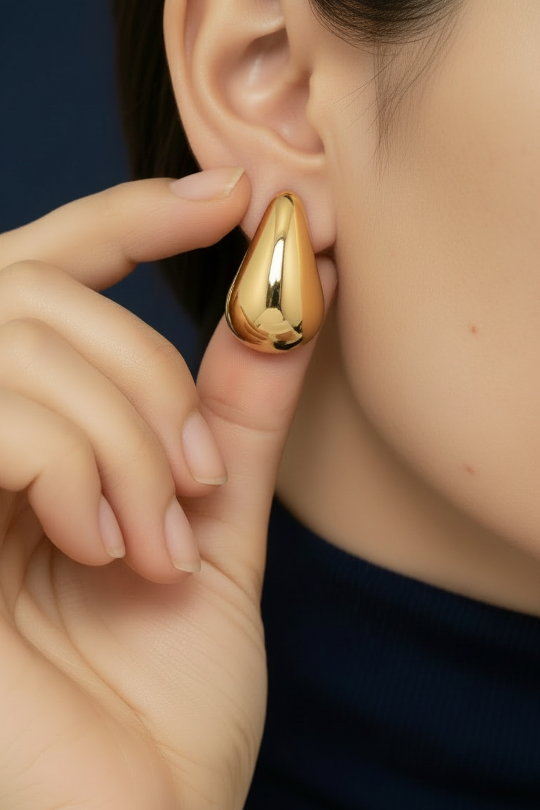 Dark background gold teardrop earring model